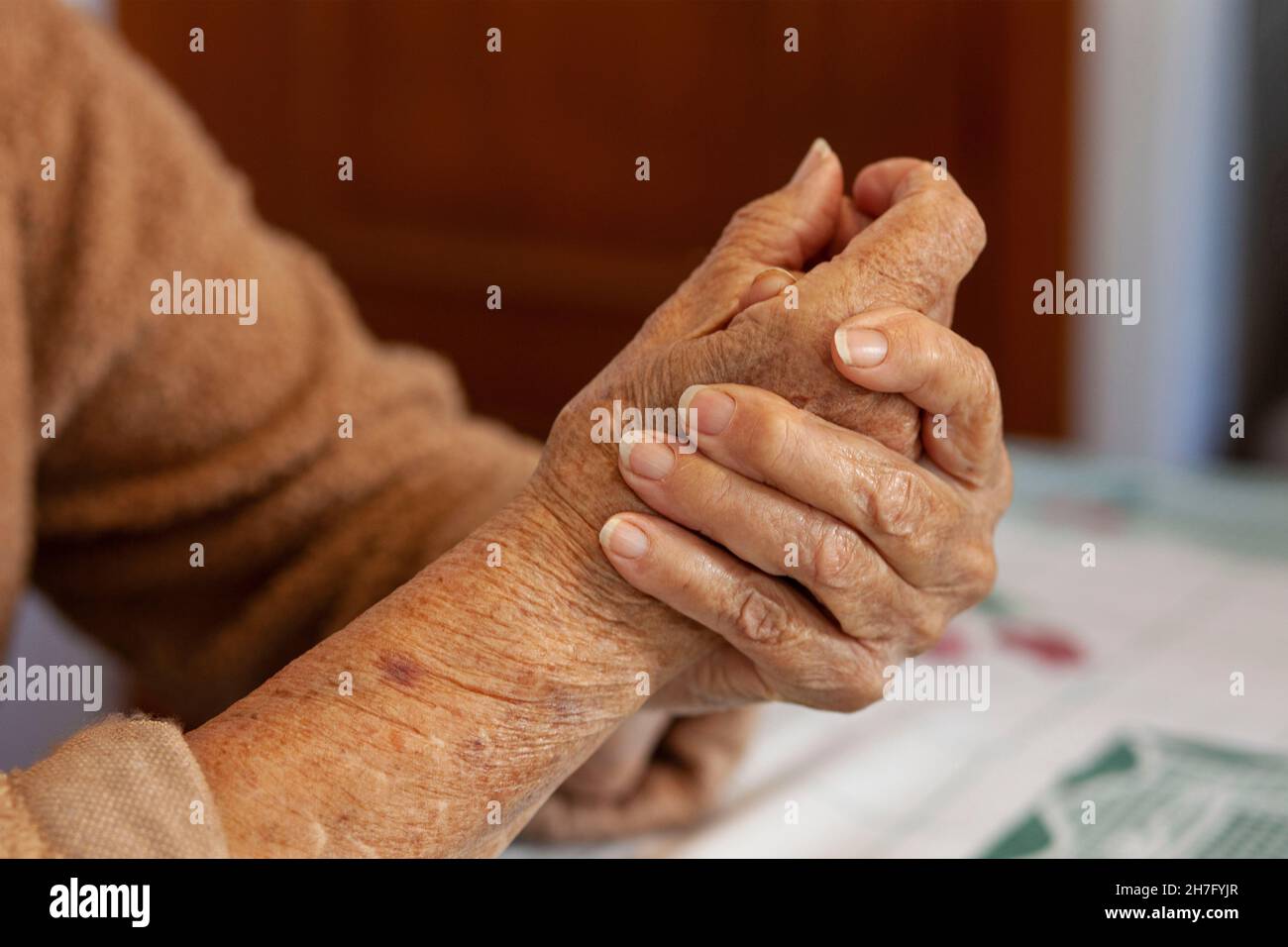 Eine Nahaufnahme der Hände einer älteren Frau, die Mr - Model umklammert, wurde veröffentlicht Stockfoto
