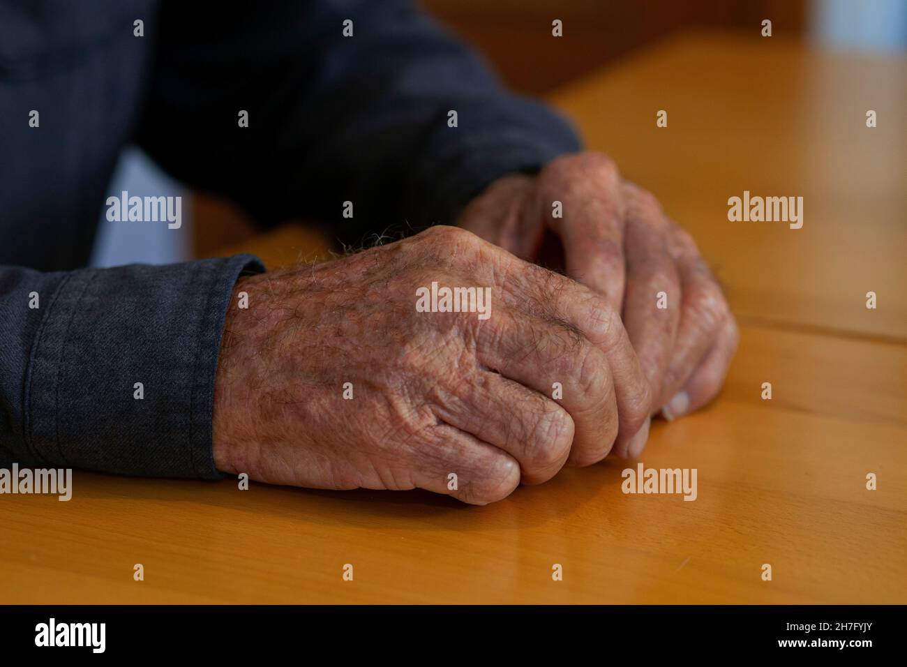 Eine Nahaufnahme der Hände eines älteren Mannes, der die Hände zusammenklammernde MR - Model, wurde veröffentlicht Stockfoto