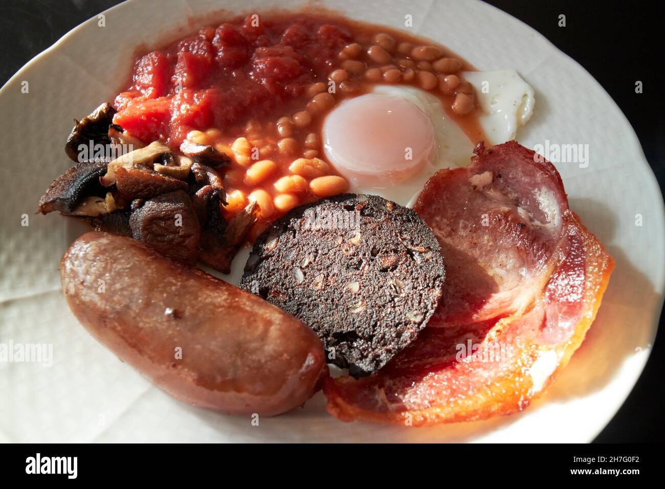 Low cost Cafe gebratenes englisches Frühstück Ei Speck Wurst Black Pudding Bohnen Tomaten und Pilze New Brighton The Wirral merseyside großbritannien Stockfoto
