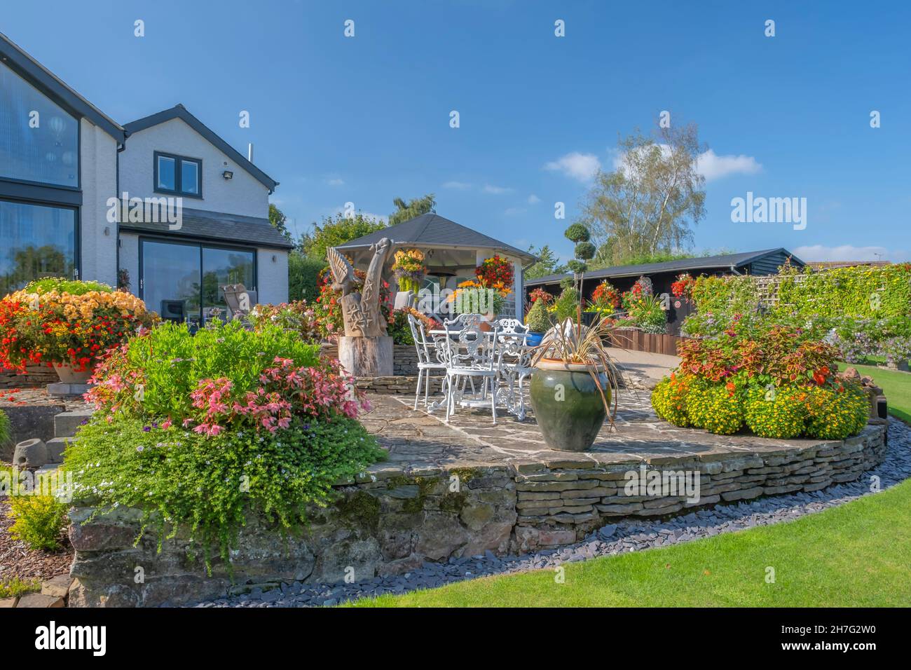 Wunderschöne Blumenkäbel und Körbe vor einem Haus. Stockfoto