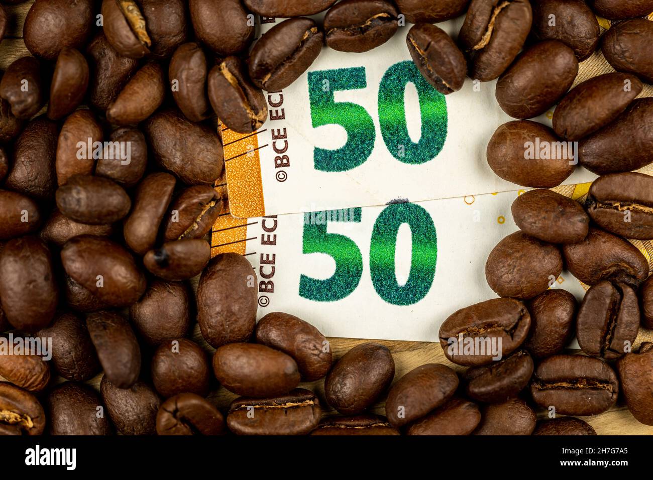 Geröstete Kaffeebohnen zusammen mit 50 Euro Rechnung. Hoher Preis für Kaffee. Pictute in gutem Kunstlicht aufgenommen. Stockfoto