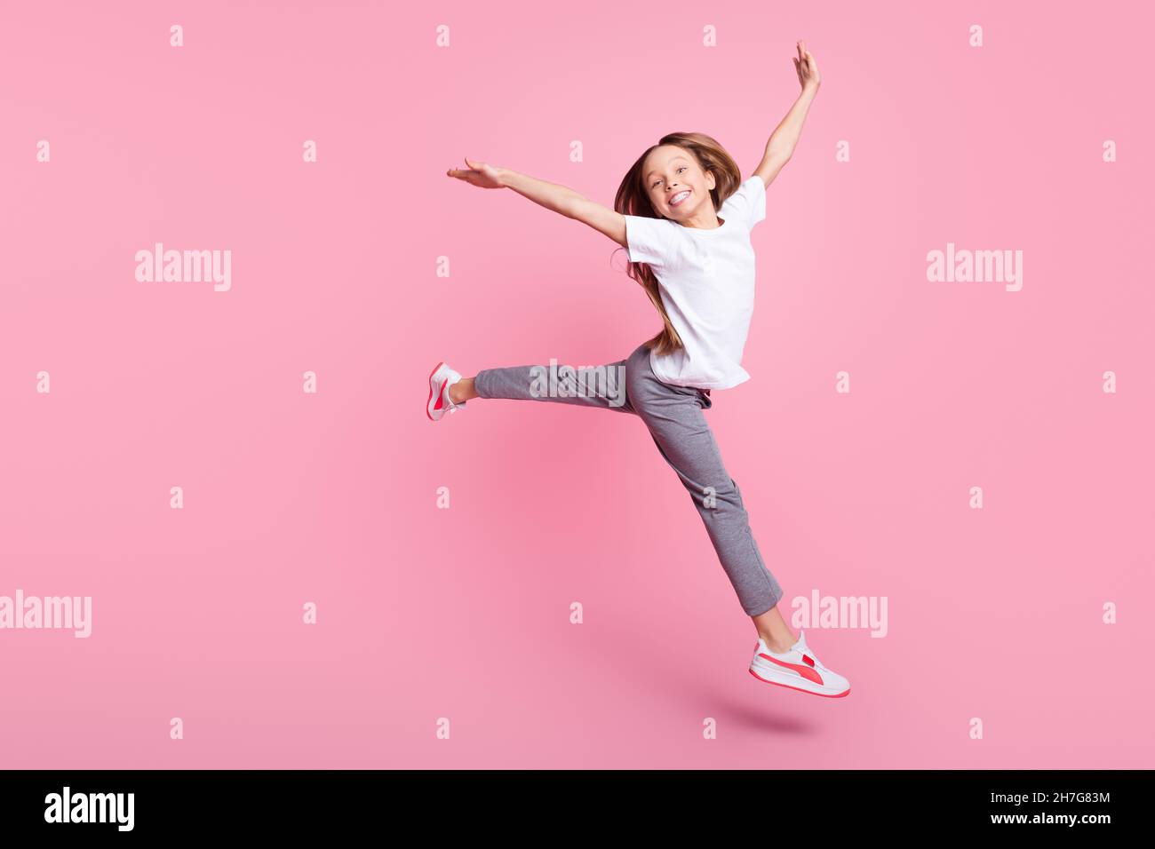 In voller Länge Körpergröße Ansicht der ziemlich kindisch fröhlich Mädchen springen Spaß isoliert über rosa Pastellfarbe Hintergrund Stockfoto