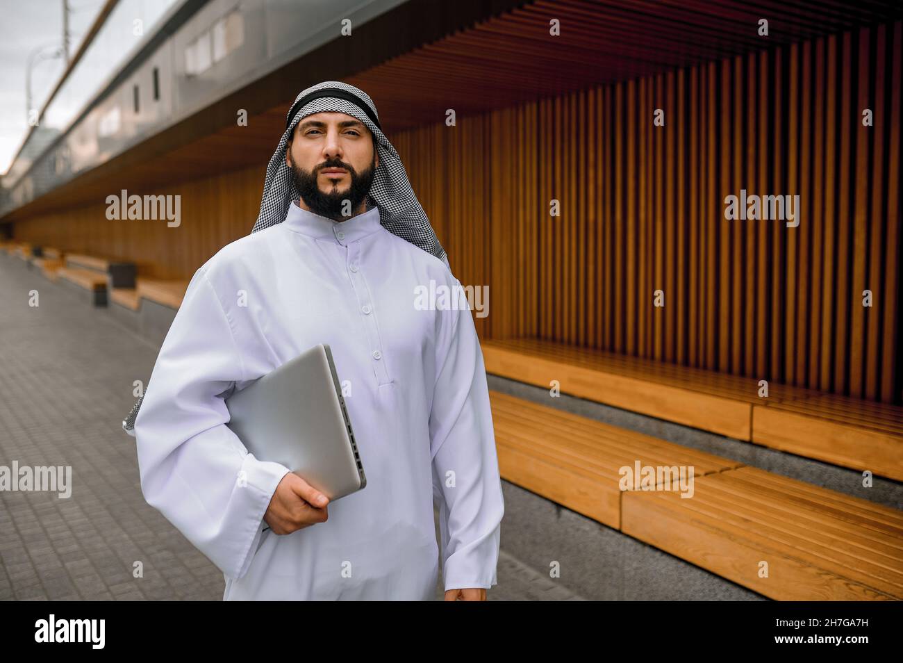 Junger arabischer Geschäftsmann mit einem Laptop in den Händen Stockfoto