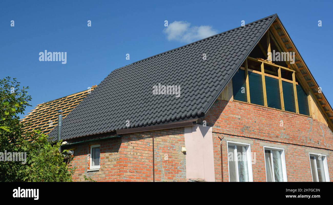 Dachkonstruktion. Eine Ziegelhausrenovierung mit einer Giebel-Dachreparatur auf der Bühne der Dachkonstruktion, Metalldachziegel und Dachfenster Installation. Stockfoto