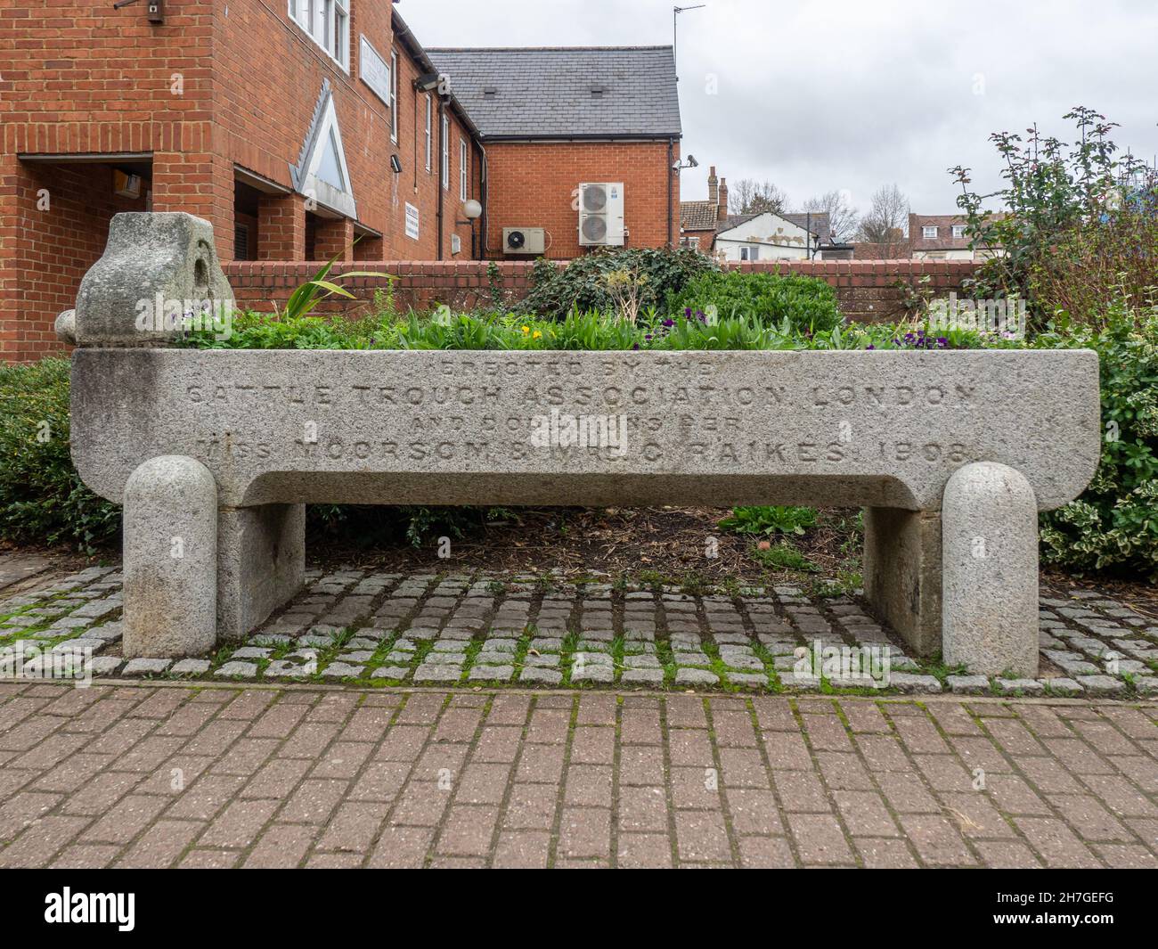 Steinerne Rinderwanne in der Marktstadt Buckingham, Großbritannien; errichtet von der Cattle Trough Association London 1998, jetzt als Blumentopf genutzt Stockfoto
