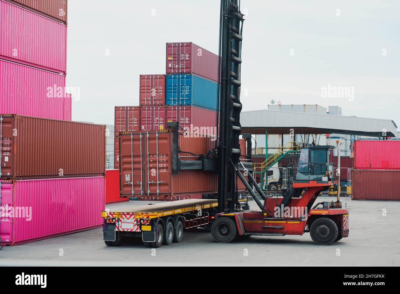 Arbeiten im Containerhof und das Auto hebt an. Frachtcontainer im Güterbahnhof Stockfoto