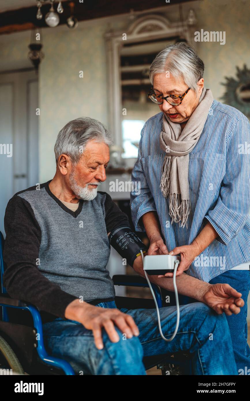 Seniorenpaar zu Hause, das den Blutdruck misst. Home Monitoring People Healthcare Konzept Stockfoto