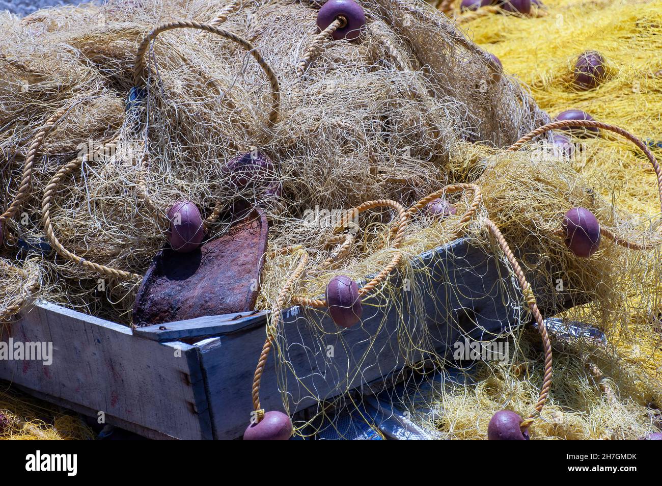 Nahaufnahme Füllansicht einer hölzernen Fischschale, gefüllt mit Fischernetzen und Seilen mit Plastikschwimmern Stockfoto