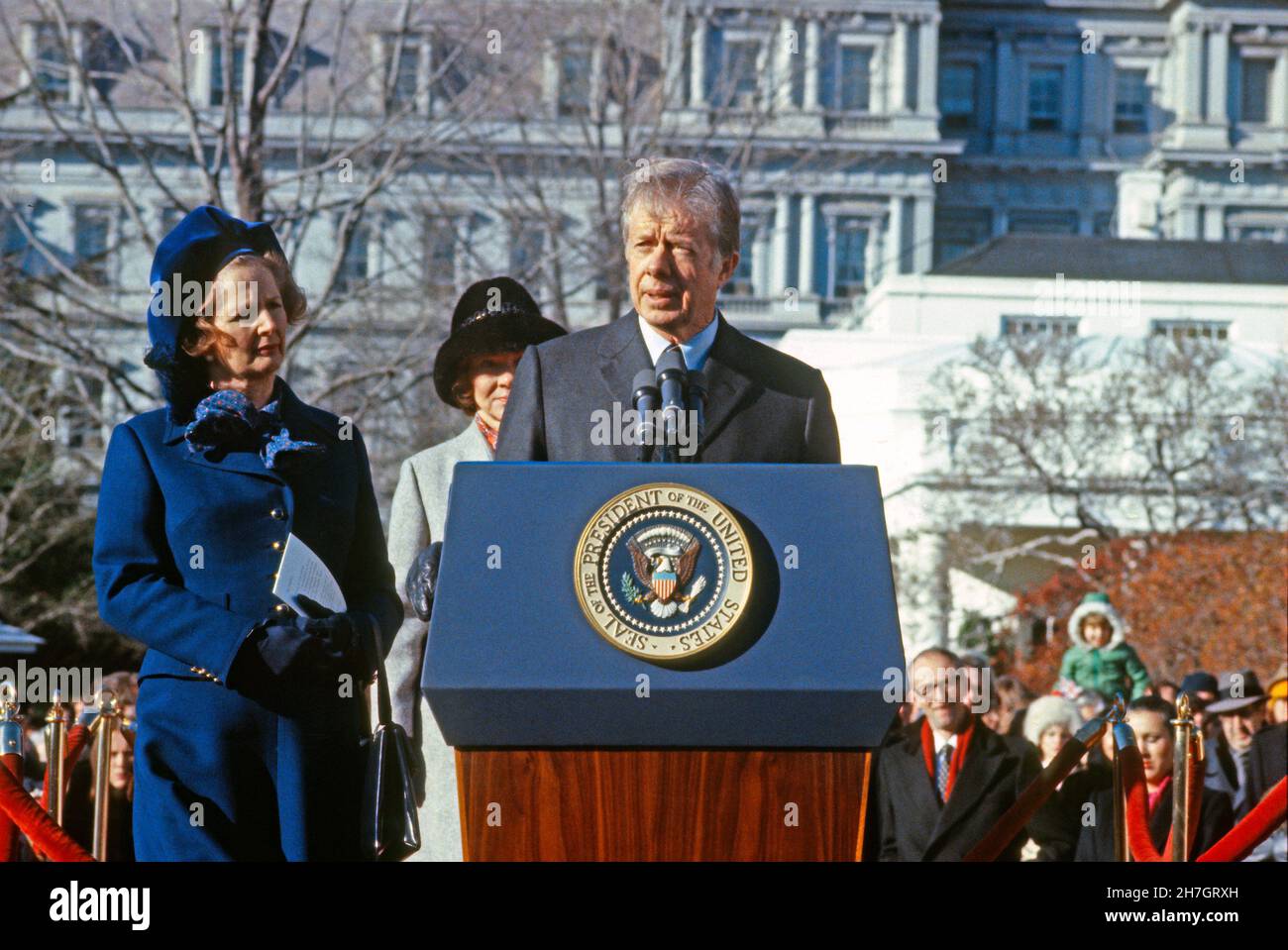 Die Rechte des US-Präsidenten Jimmy Carter nimmt willkommene Bemerkungen vor, während die britische Premierministerin Margaret Thatcher am Montag, dem 17. Dezember 1979, die Begrüßungszeremonien im Weißen Haus in Washington, DC, zu ihren Ehren zuhört. In ihren Bemerkungen lobte sie den Umgang mit der Presidents-Geiselkrise mit dem Iran, indem sie sagte, er habe weltweit für seinen Mut und seine Geduld Respekt gewonnen. First Lady Rosalynn Carter, Mitte, schaut zu. Kredit: Benjamin E. 'Gene' Forte - CNP Stockfoto