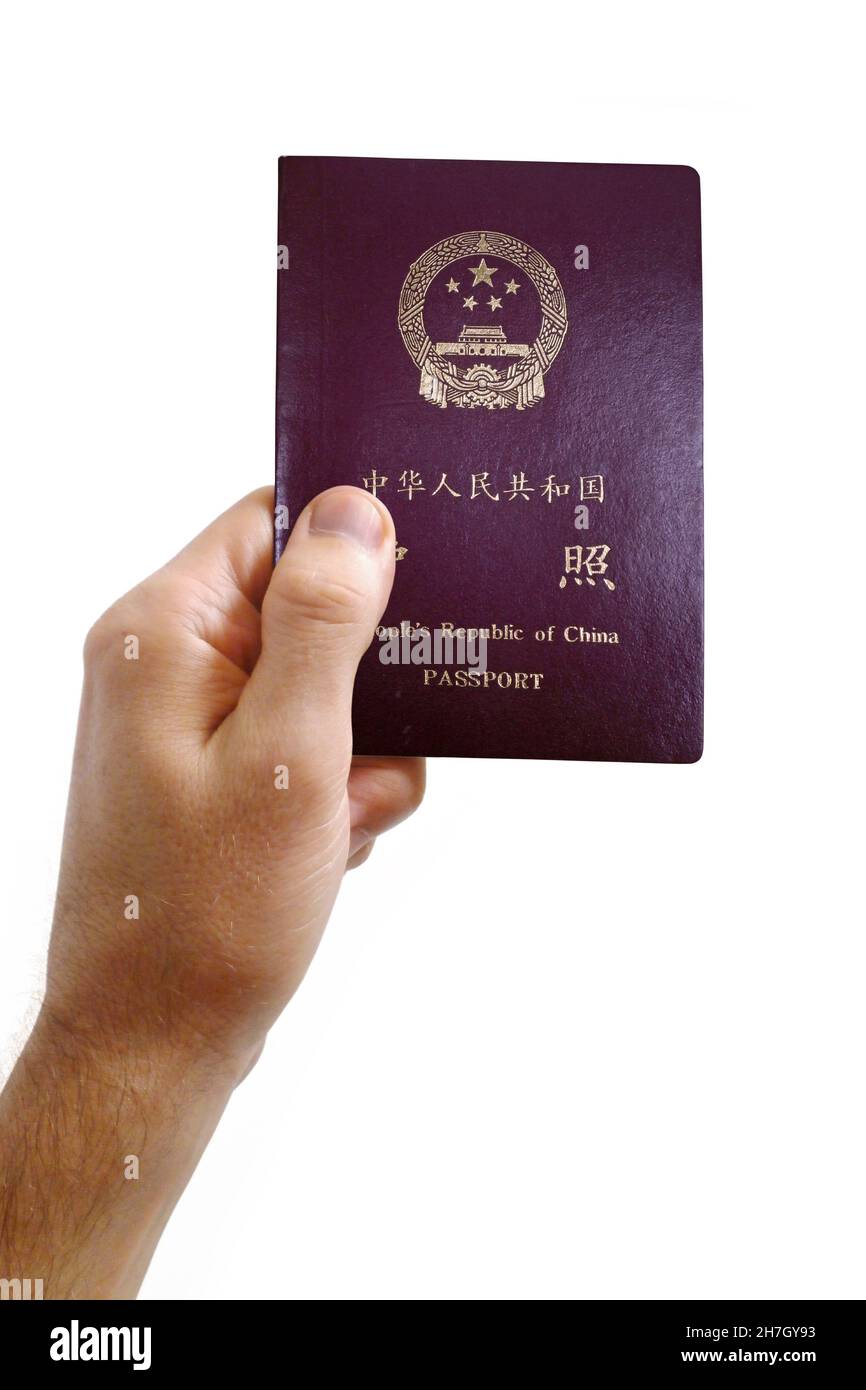 Nahaufnahme auf der Hand eines Mannes mit einem chinesischen Pass vor weißem Hintergrund. Stockfoto