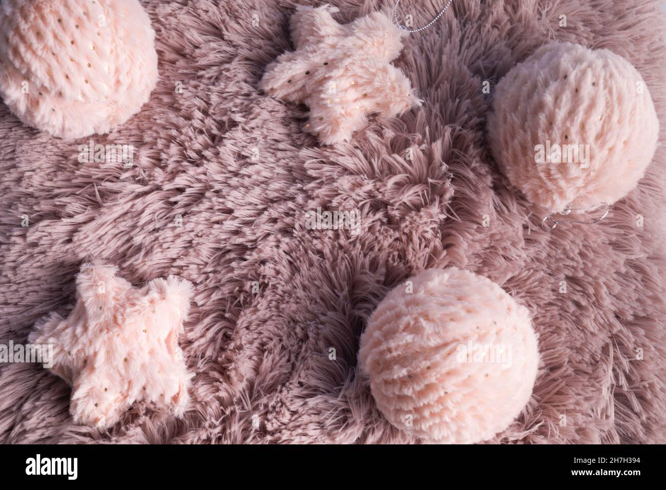 Weihnachtshintergrund mit rosa Fellkugeln auf rosa Fellhintergrund. Winterferien Hintergrund. Winterstimmung Stockfoto