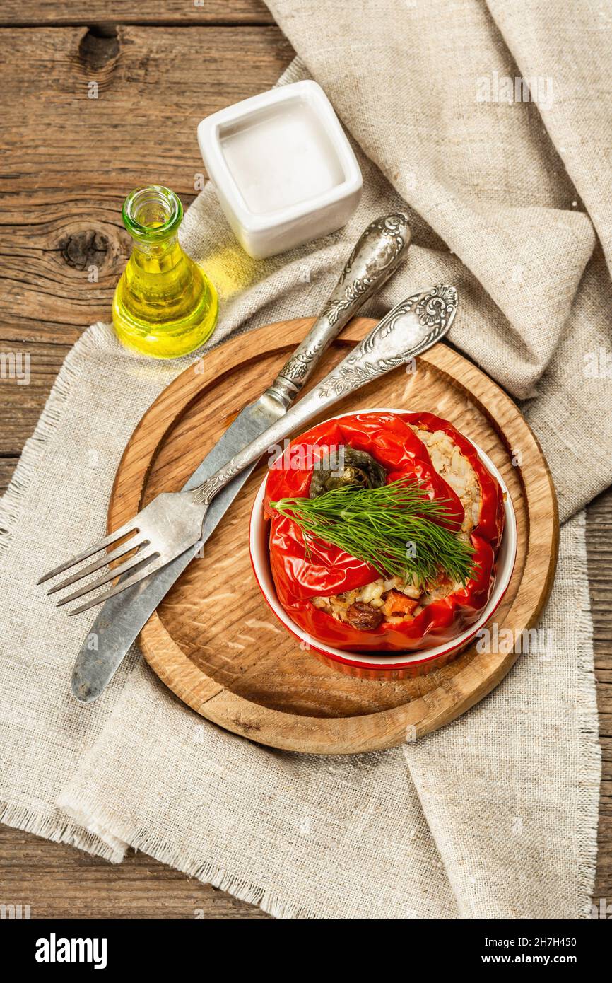 Hausgemachtes Fleisch und Reis gefüllte Paprika. Olivenöl, Sauce, Besteck. Traditionelles gesundes Essen, Vintage Holzhintergrund, Draufsicht Stockfoto