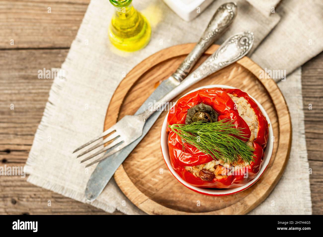 Hausgemachtes Fleisch und Reis gefüllte Paprika. Olivenöl, Sauce, Besteck. Traditionelles gesundes Essen, Vintage Holzhintergrund, Draufsicht Stockfoto