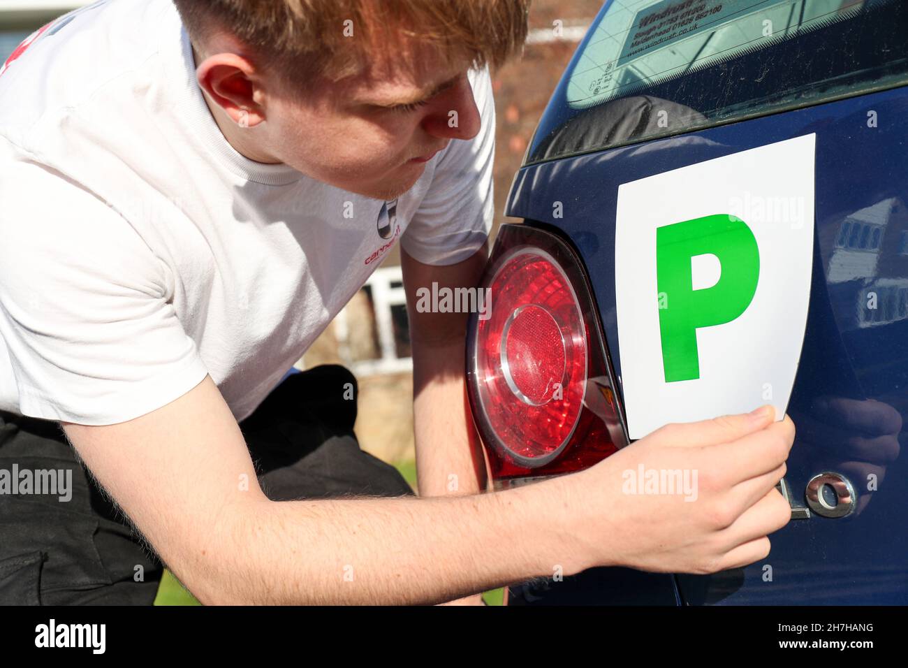 Ein neuer junger Fahrer, der in Großbritannien P-Platten auf sein Auto setzte. Stockfoto