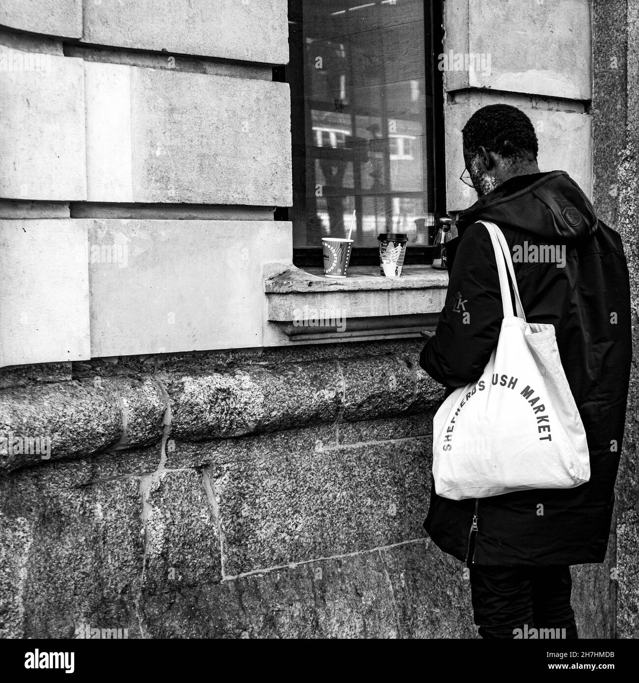 Victoria Westminster London England Großbritannien, November 7 2021, Schwarzer Mann, der alleine vor der Victoria Station mit Einem Take Away Coffee steht Stockfoto