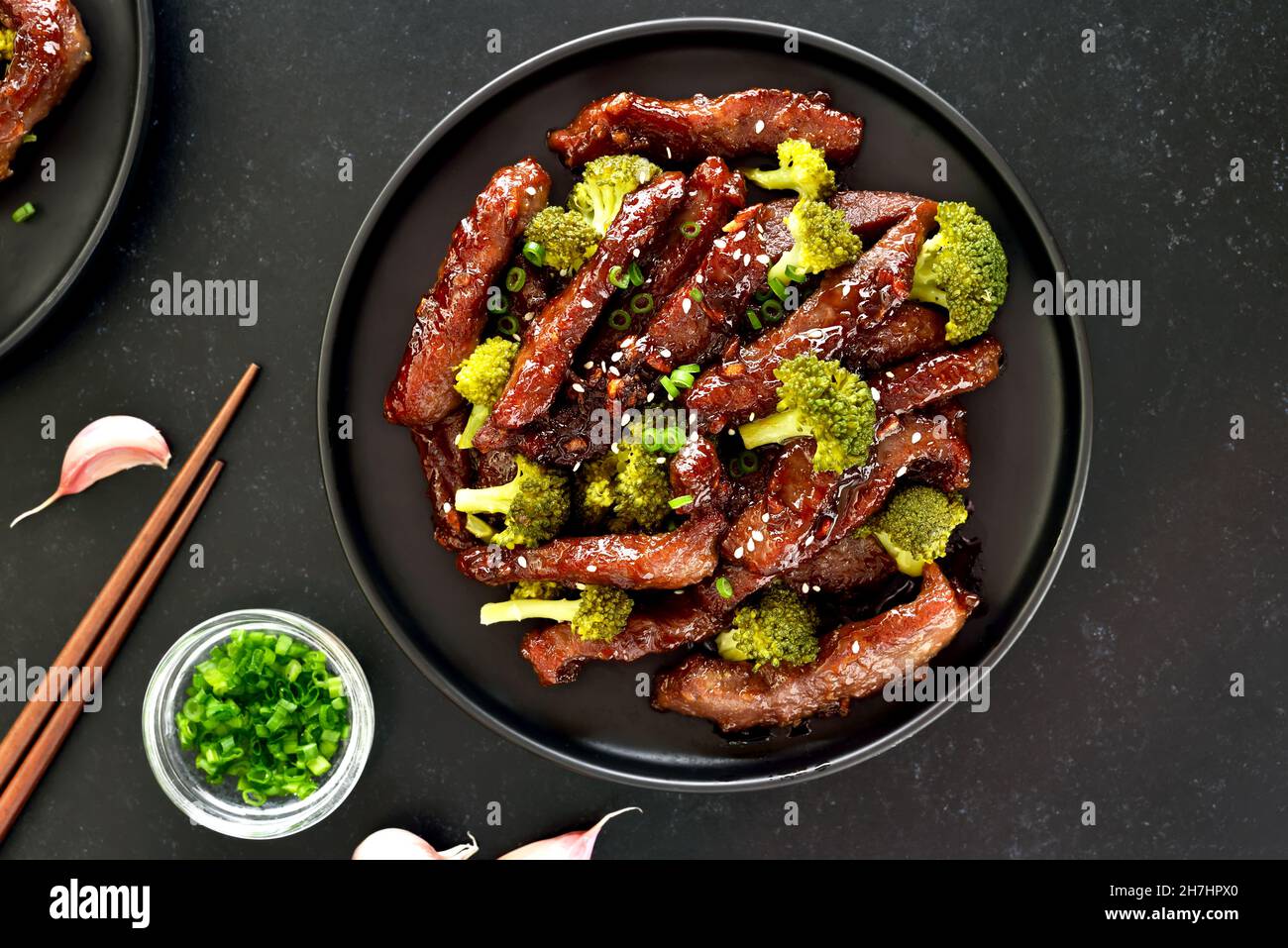 Rindfleisch und Brokkoli unter Rühren auf dunklem Grund braten. Draufsicht, flach liegend Stockfoto