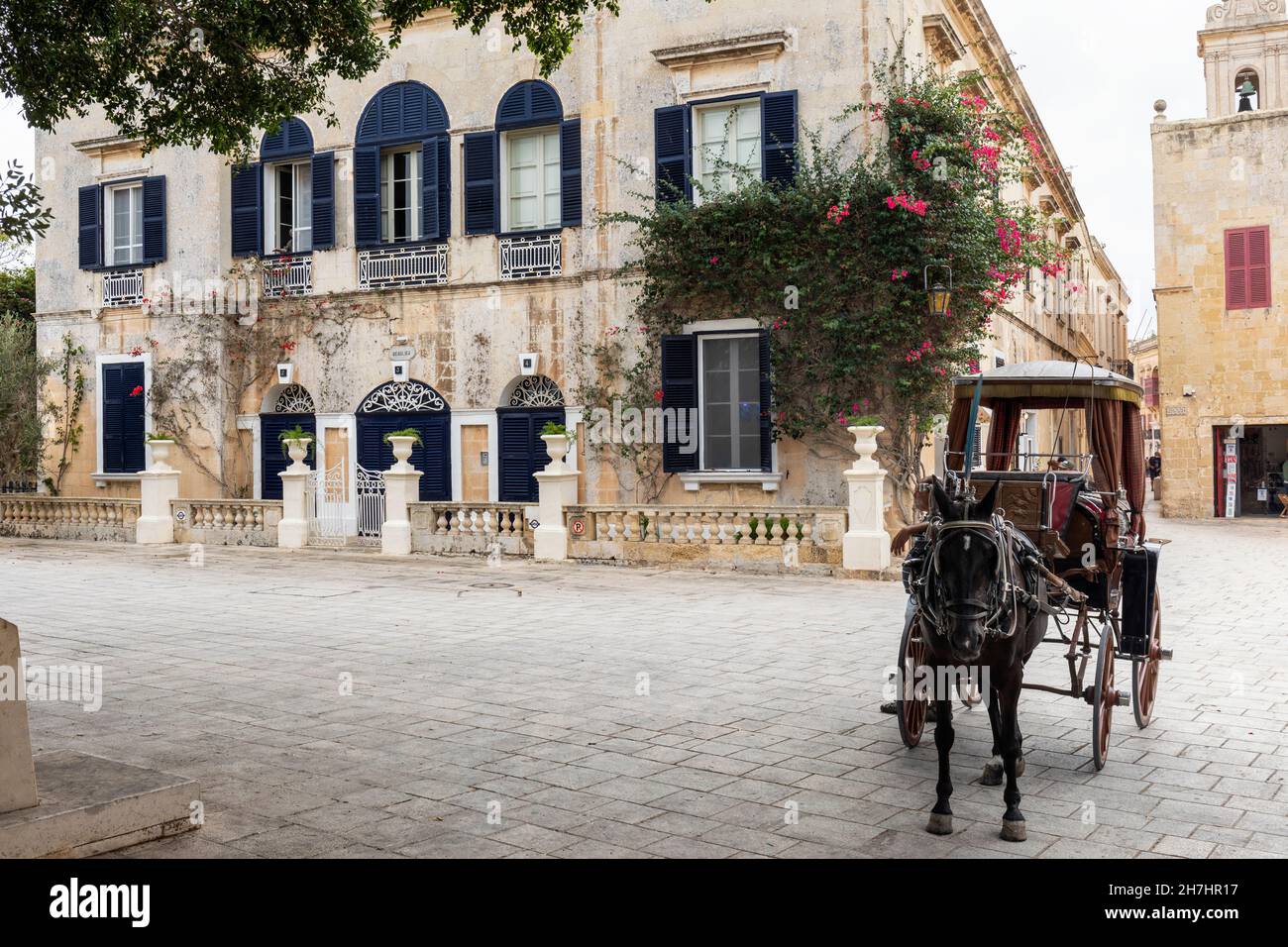 Traditionelle Architektur und Pferd und Wagen auf dem Bastion-Platz in der stillen Stadt Mdina, Malta. Eine alte ummauerte Stadt auf der UNESCO-Liste des Weltkulturerbes Stockfoto