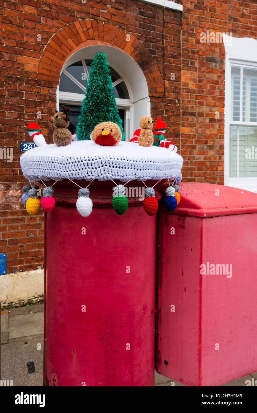 Gehäkelte und gestrickte Weihnachtsdekoration auf einer Briefbox in Grantham, Lincolnshire, England. Bombenangriffe auf Garn Stockfoto