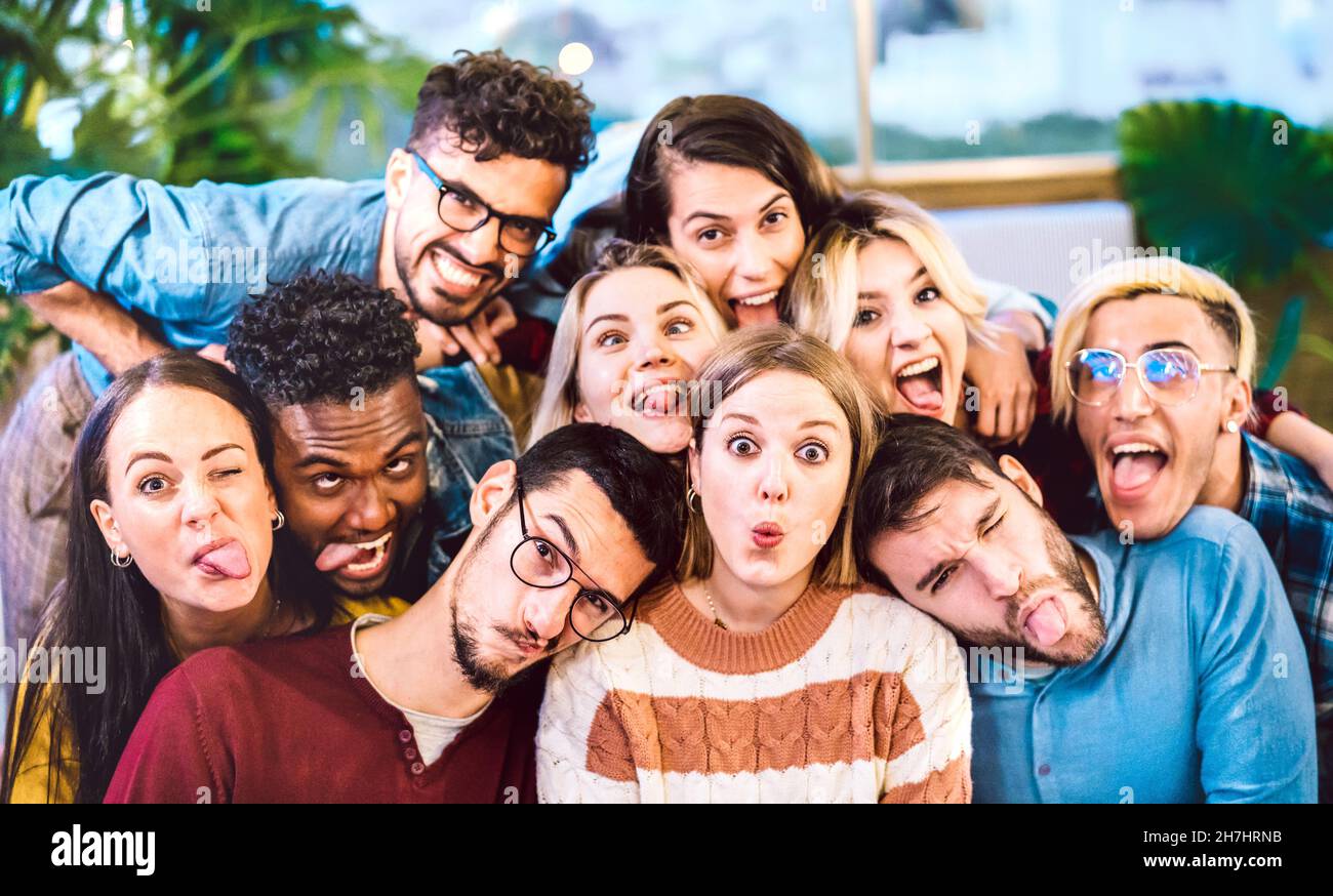 Multikulturelle Männer und Frauen, die Selfie machen, ragen aus der Zunge mit verrückten lustigen Gesichtern - Lebensstil und Integrationskonzept Stockfoto