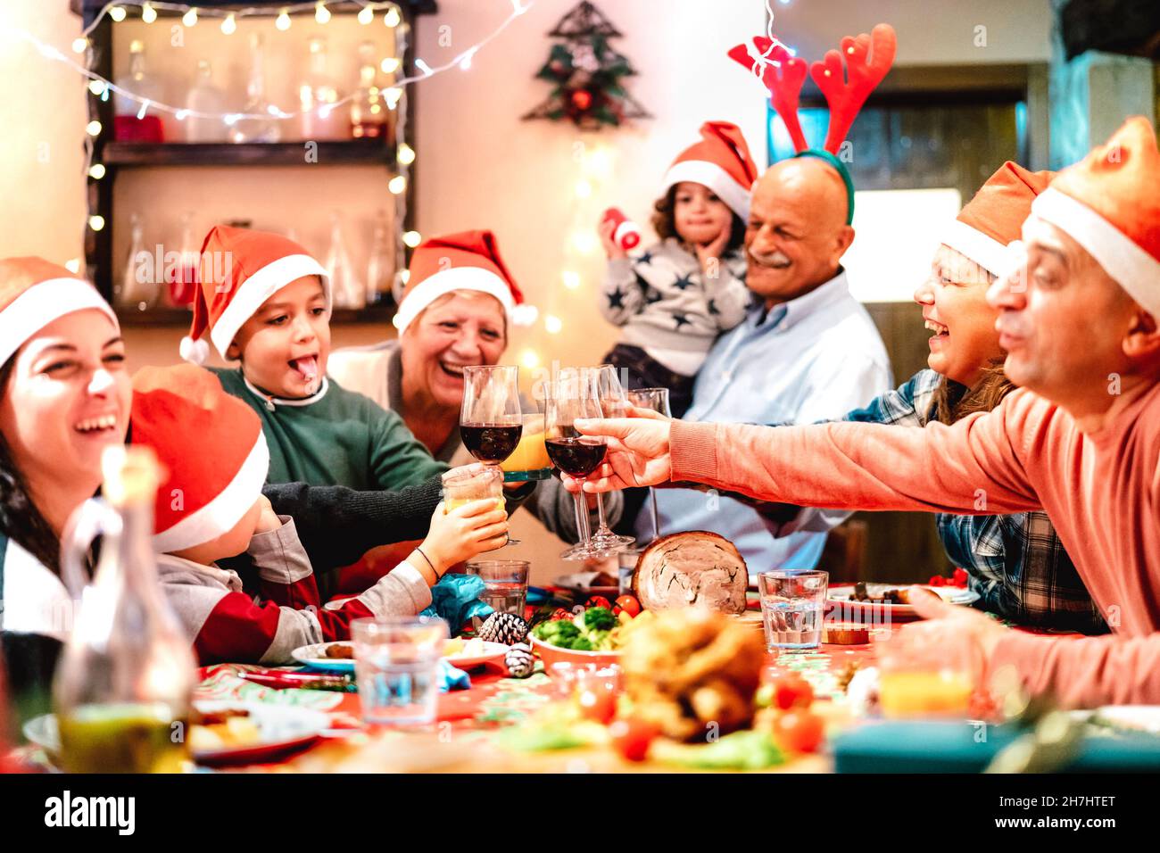 Große Multi-Generation-Familie Toasting beim weihnachtsessen Fest - Winterurlaub Weihnachten Konzept mit Eltern und Kindern zusammen zu Hause Abendessen essen Stockfoto