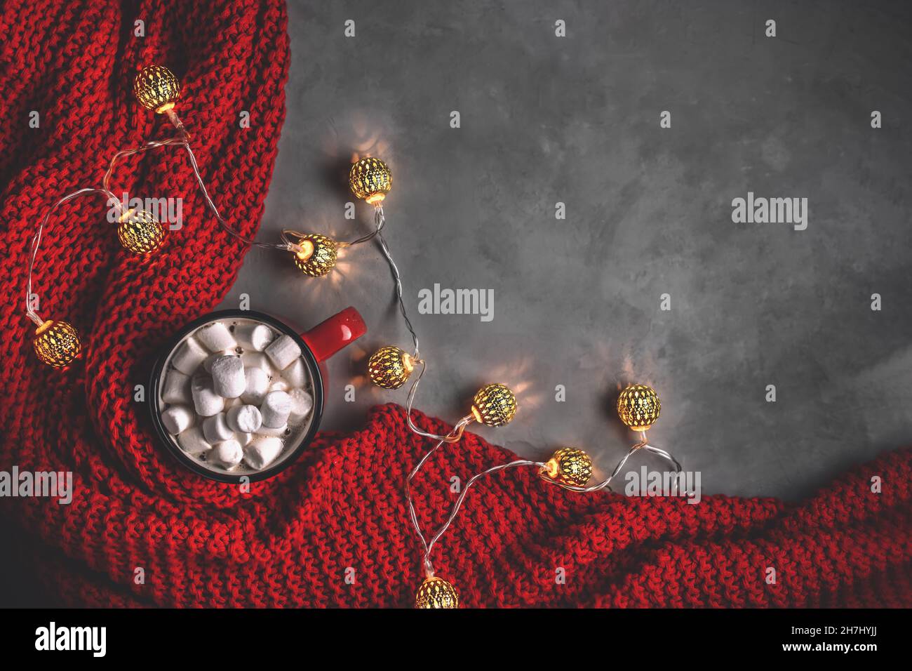 Becher mit Süssmarmelibe, Girlanden, roter Decke auf grauem Hintergrund. Neujahr, weihnachten. Mit Kopierraum, Draufsicht Stockfoto