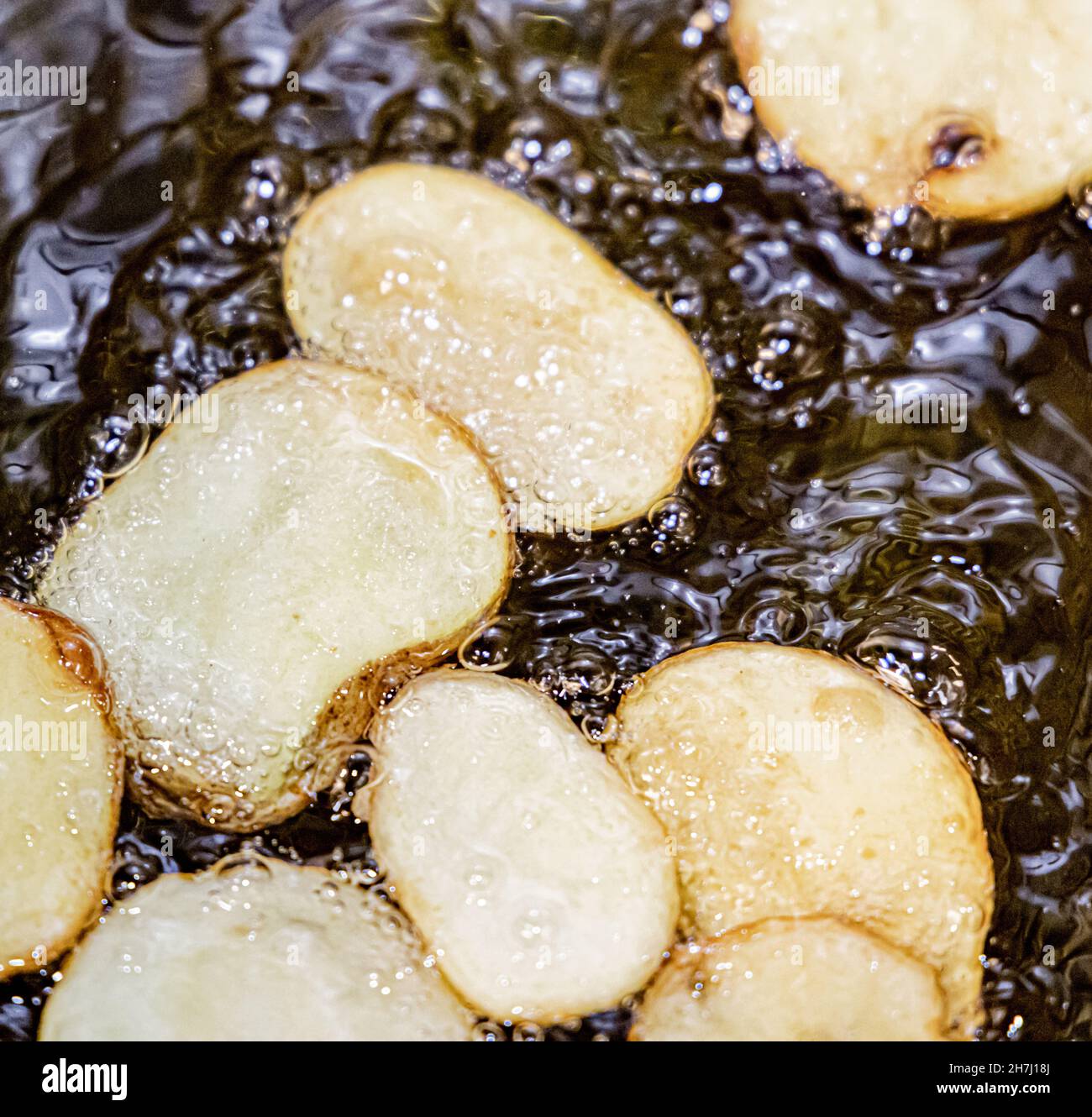 Frische Kartoffelscheiben in heißem Öl Stockfoto