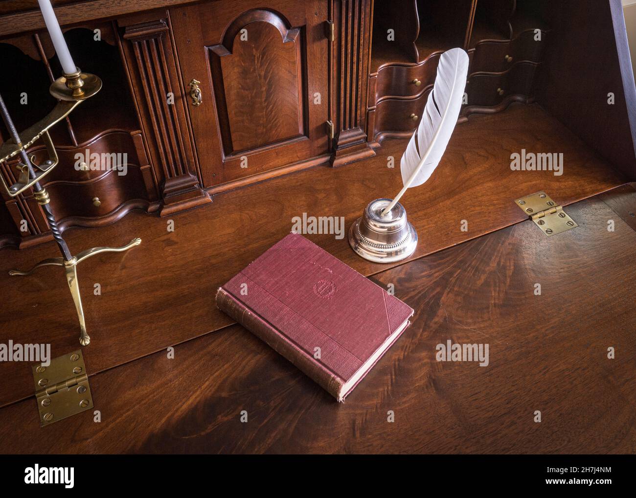 Federstift und Tinte mit Buch auf einem antiken Schreibtisch Stockfoto