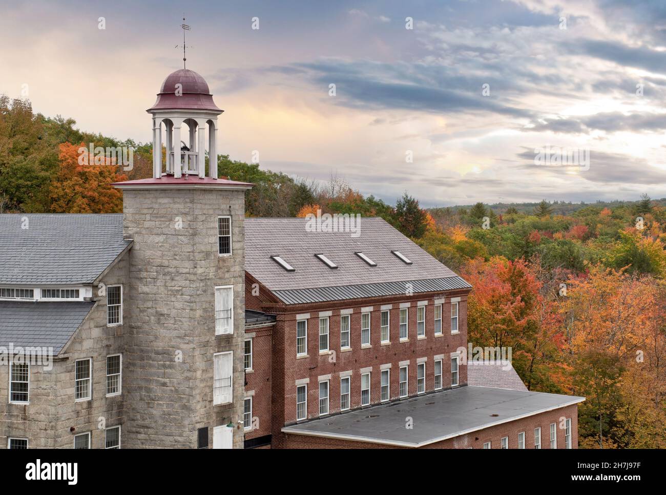 Schöner Himmel und farbenfrohe Herbstszene in der historischen Stadt Harrisville, New Hampshire. Alter Glockenturm und erhaltene Textilmühlengebäude. Stockfoto