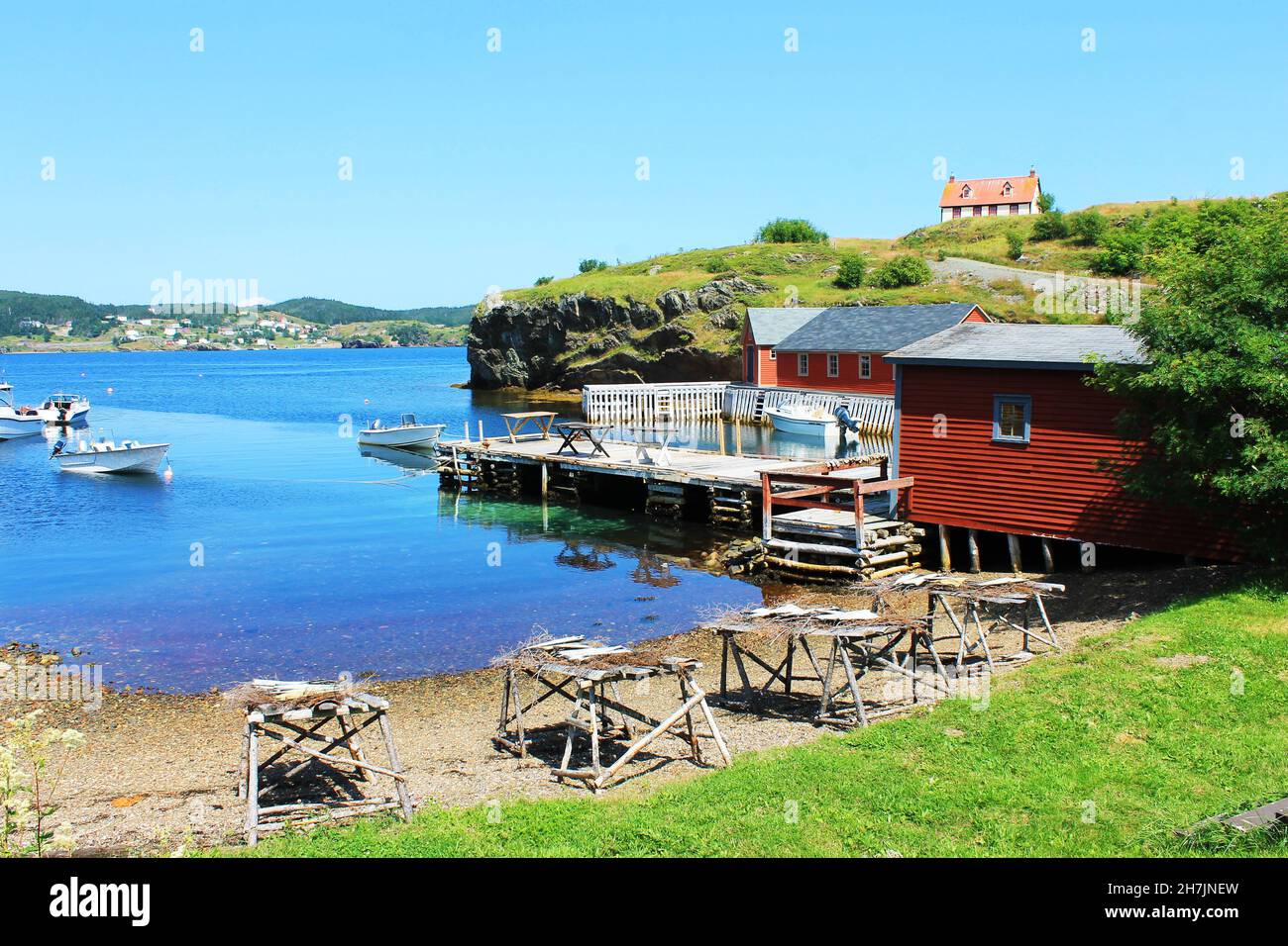 Fischerdorf, Hafenszene; Fisch trocknet auf Bühnen, Boote liegen am Pier, Trinity, Neufundland Labrador. Stockfoto