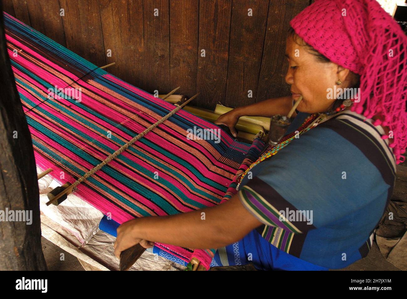 Mit einem traditionellen Webstuhl webt eine Frau aus Moeun (Ethnie) Material für Moeun-Kostüme im Dorf Pan AWH im südlichen Chin-Staat, Myanmar. Stockfoto