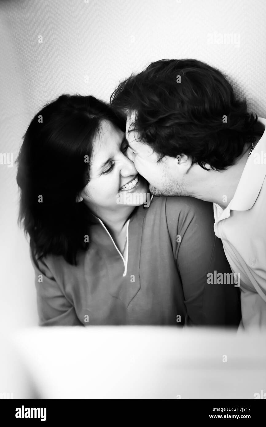Porträt eines küssenden Paares in schwarz-weiß. Das Konzept einer glücklichen Familie. Vorderansicht. Stockfoto