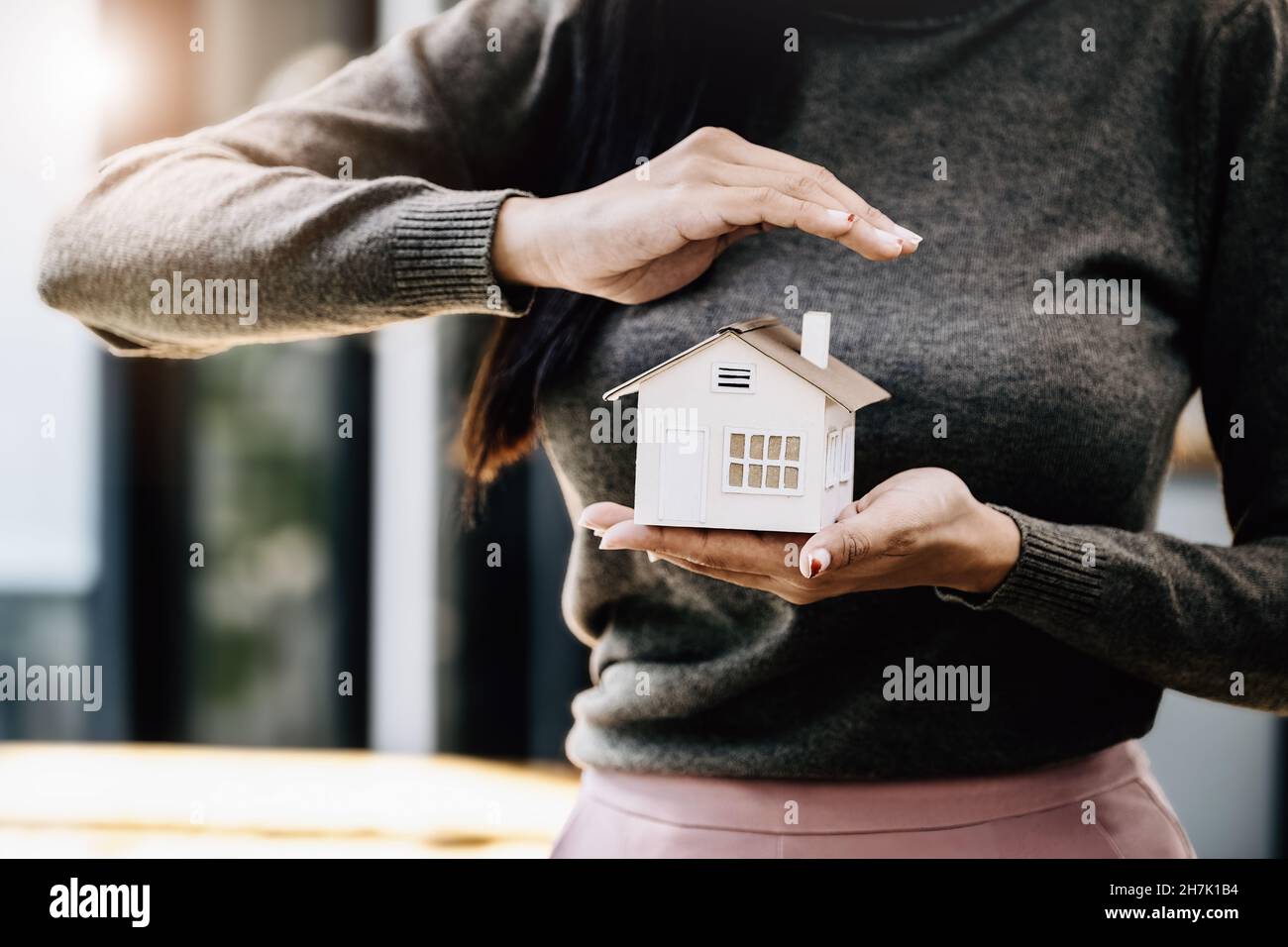 Immobilienmakler gesturing, um Häuser zu schützen, Wohnungsversicherung Konzept. Stockfoto