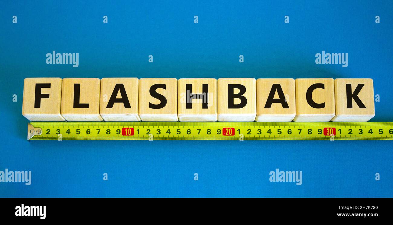 Flashback-Symbol. Das Konzeptwort Flashback auf Holzwürfel. Gelbes Lineal. Schöner blauer Tisch, blauer Hintergrund. Business- und Flashback-Konzept. Cop Stockfoto