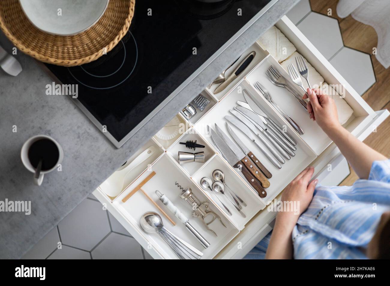 Draufsicht closeup Hausfrau Hände aufräumen Besteck in Schublade allgemeine Reinigung in der Küche Stockfoto