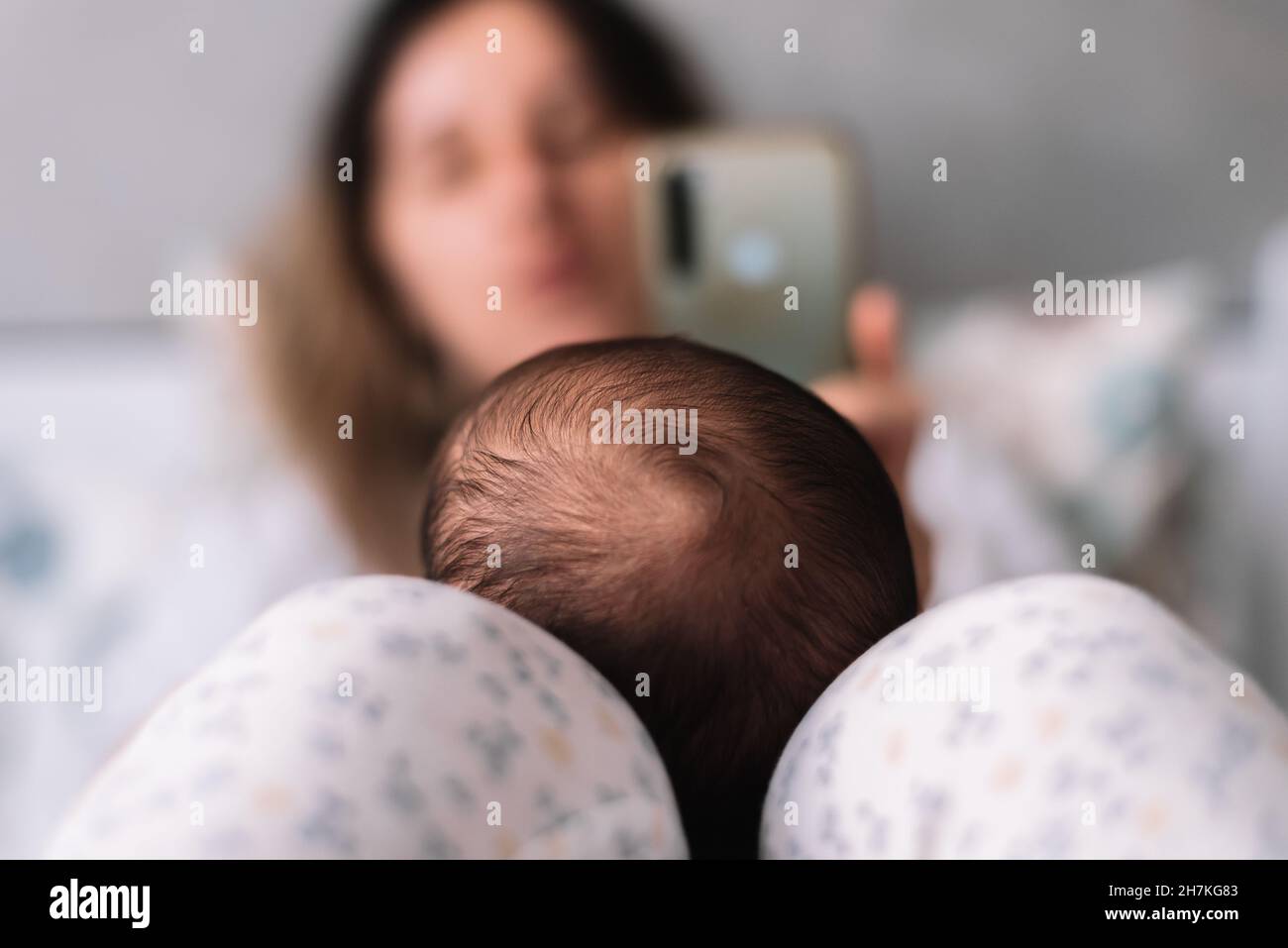 Mutter, die mit ihrem Handy ein Foto von ihrem Baby gemacht hat. Stockfoto