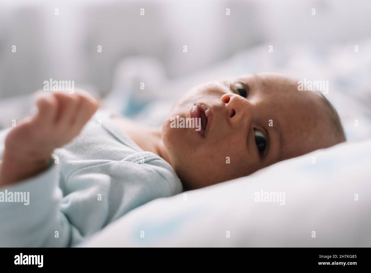 Porträt eines Neugeborenen, das im Bett liegt. Seitenansicht. Stockfoto