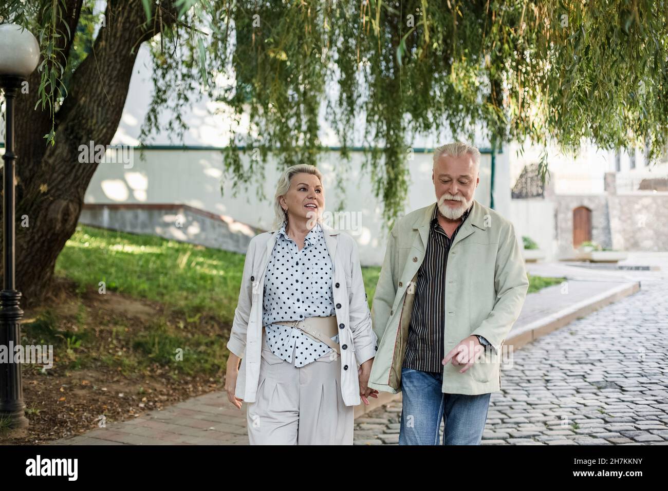 Paar hält Hände beim Gehen auf Fußweg Stockfoto