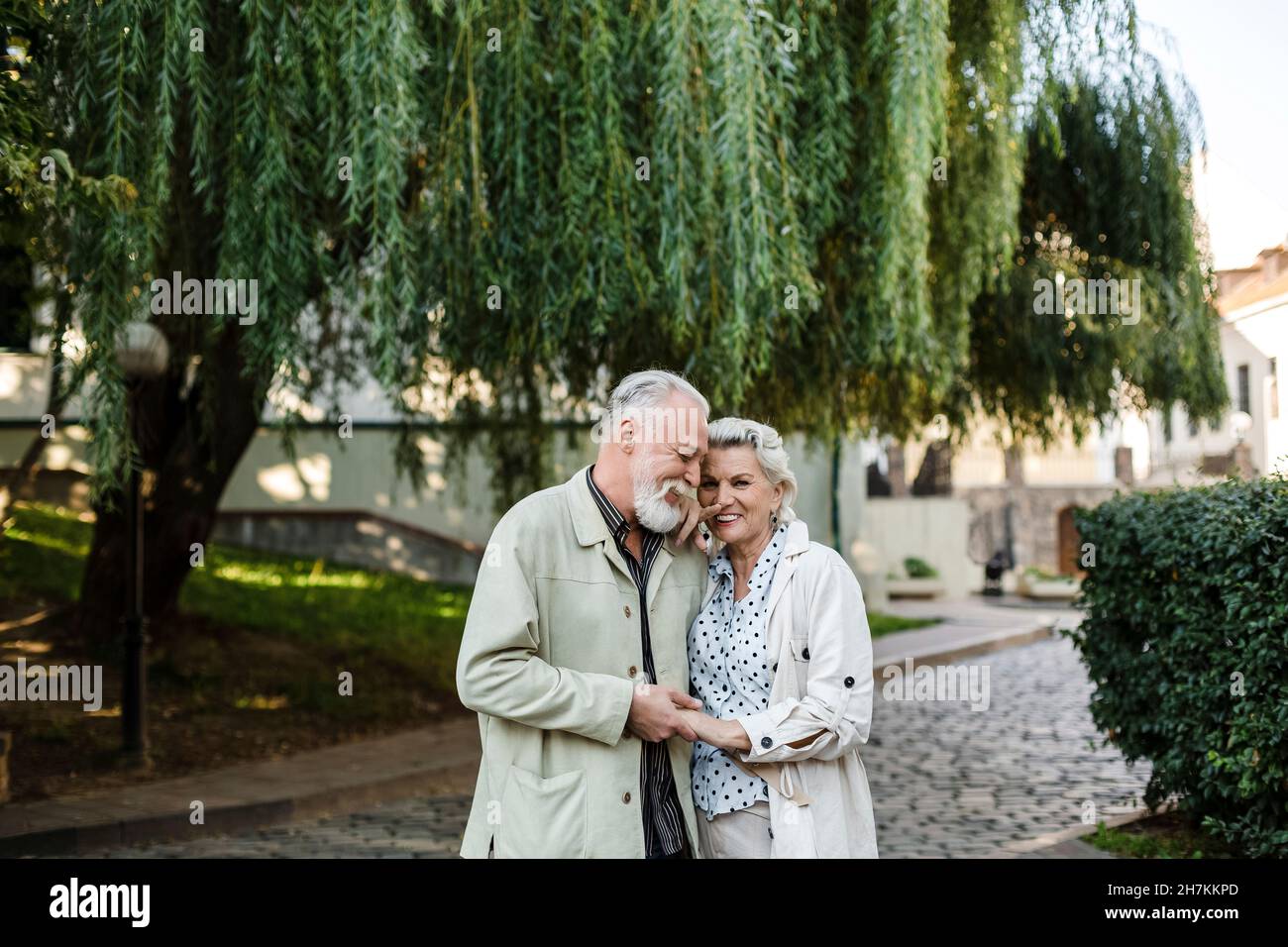 Lächelndes Paar, das die Hände am Baum hält Stockfoto