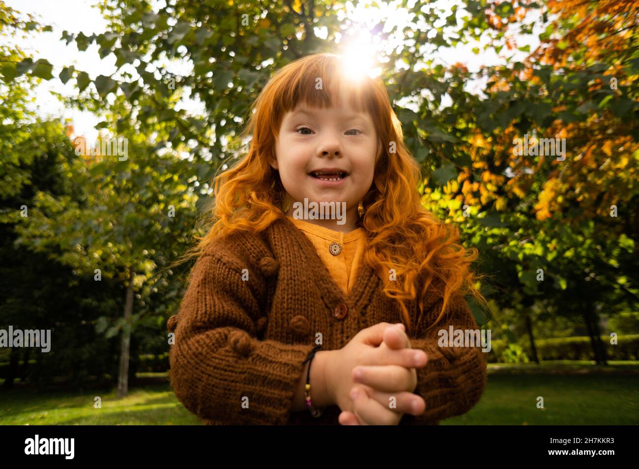 Lächelndes Mädchen mit Down-Syndrom im Park Stockfoto