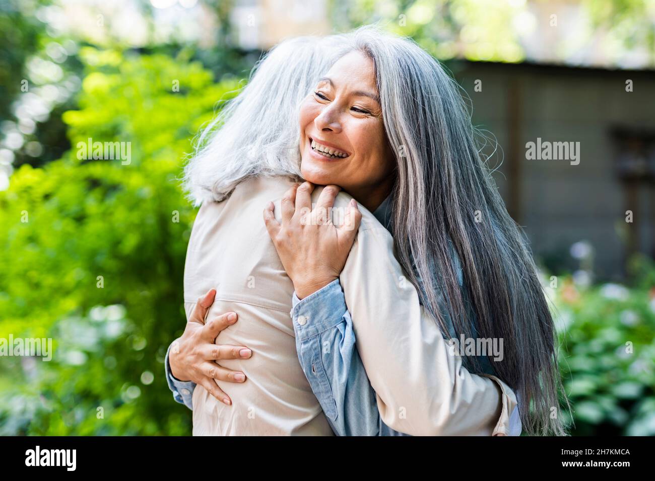 Reife Frauen mit langen Haaren umarmt weibliche Freundin Stockfoto