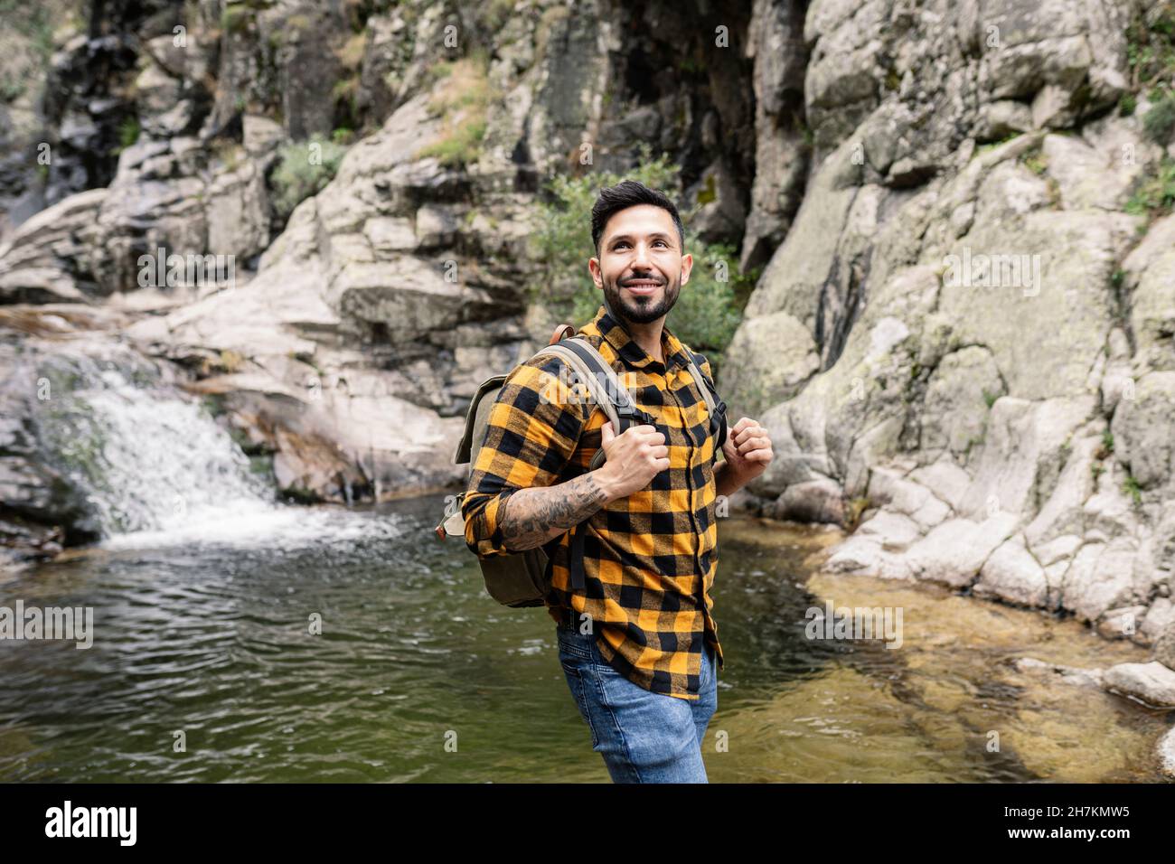 Mittlerer Erwachsener, männlicher Tourist, der Kaffee am Teich getrunken hat Stockfoto