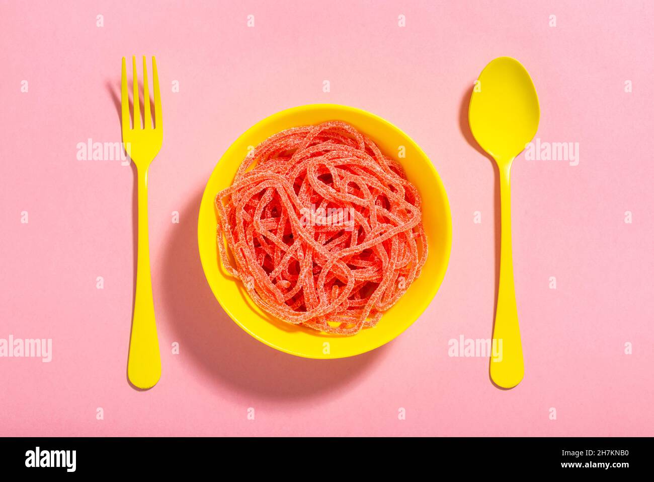 Studioaufnahme von roten Gummitropfen mit einem einzelnen schwarzen Tropfen, der heraussticht Stockfoto