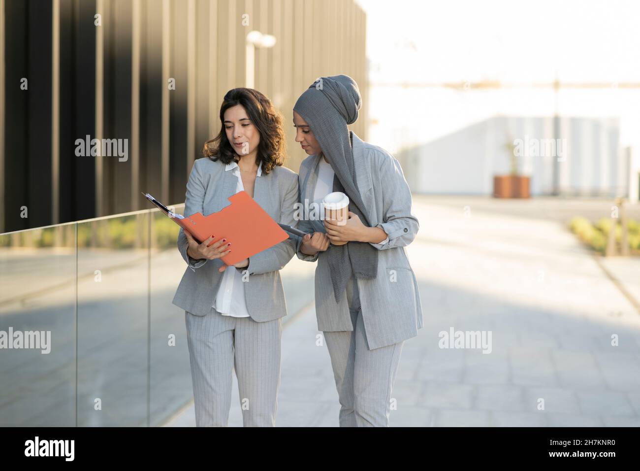 Weibliche Profis sprechen beim Gehen auf dem Fußweg Stockfoto