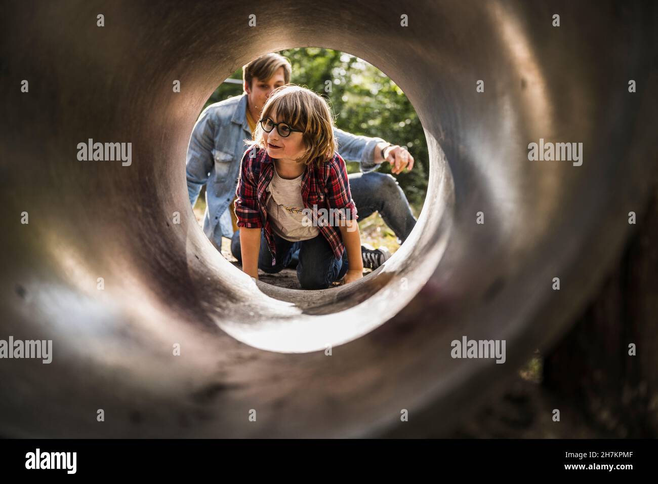Vater und Sohn sitzen am Tunneleingang im Park Stockfoto