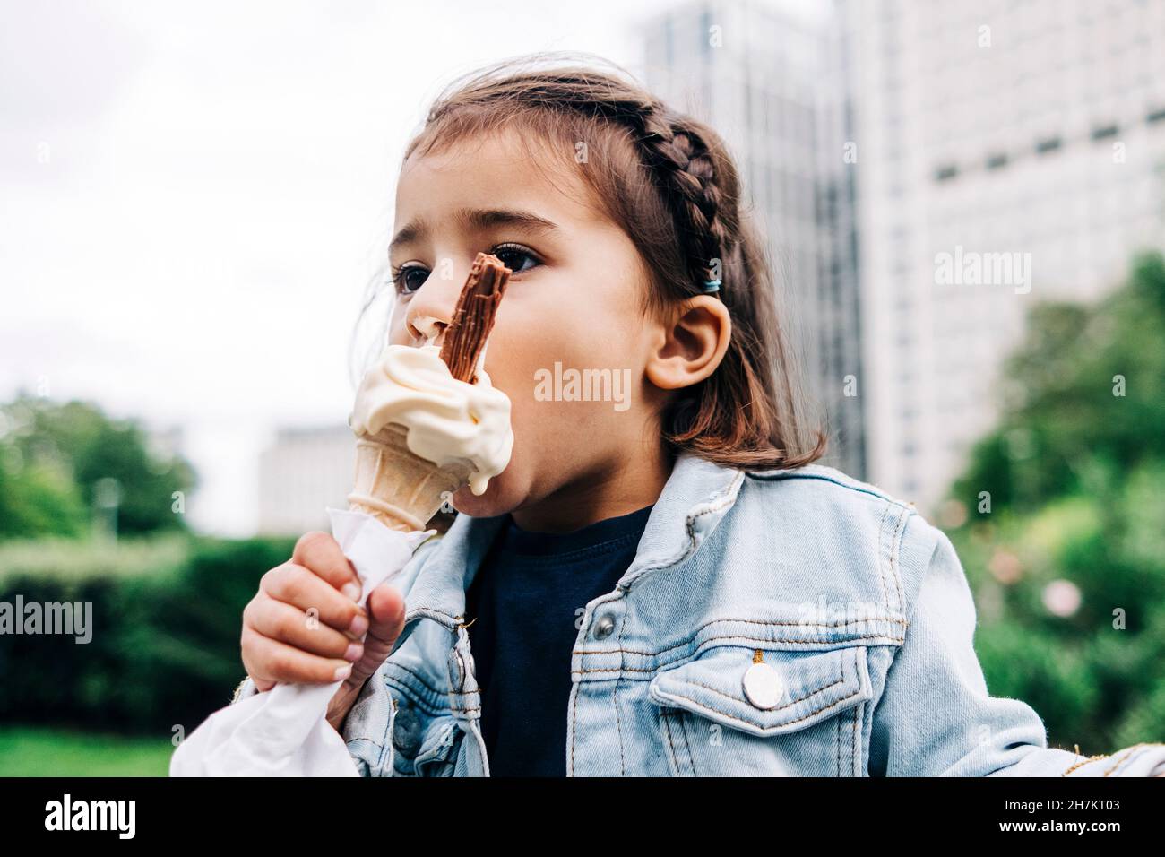 Mädchen, das Eis im öffentlichen Park isst Stockfoto