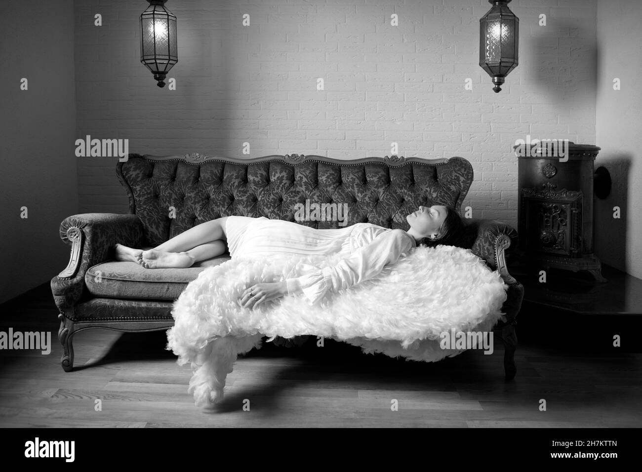 Mädchen im Engel Kostüm schlafen auf dem Sofa Stockfoto