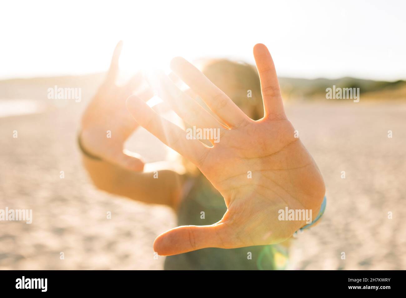 Junge Frau tut Stop-Geste mit Händen am Strand Stockfoto