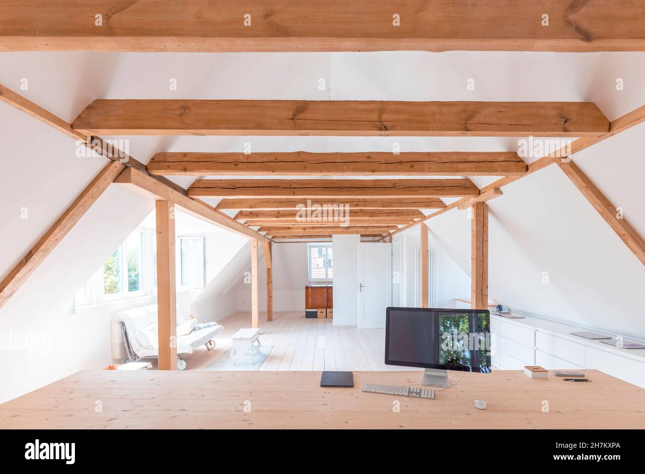 Home Dachboden mit Computer-Monitor auf Holztisch im Vordergrund Stockfoto