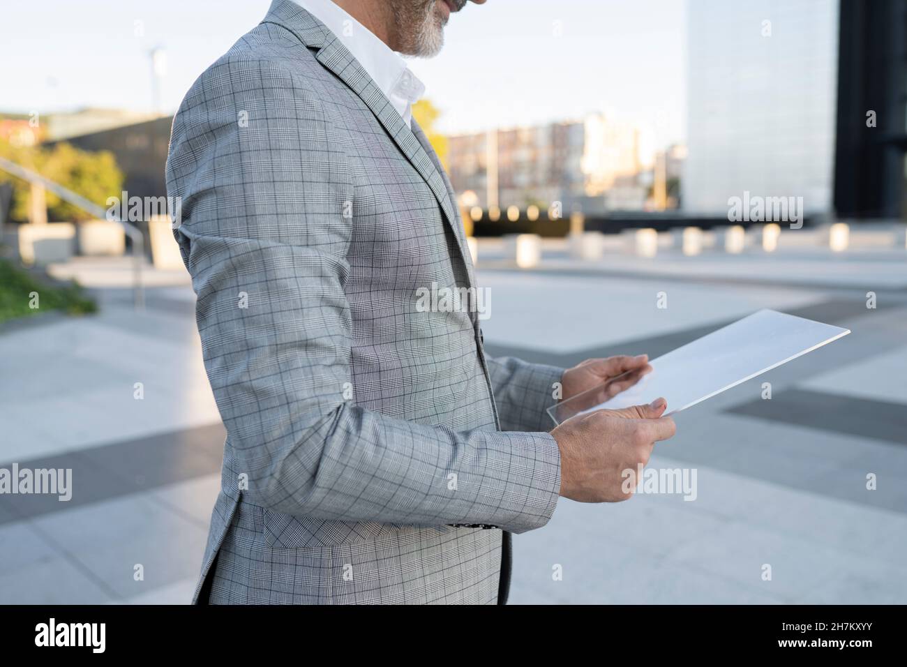 Geschäftsmann, der ein tragbares Glasgerät außerhalb des Bürogebäudes verwendet Stockfoto
