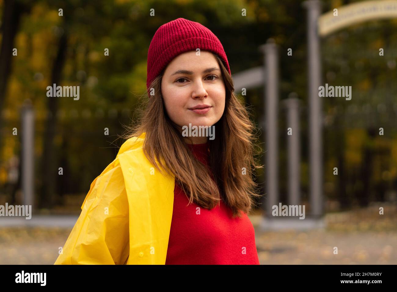 Schöne Frau in gelbem Regenmantel im Park Stockfoto